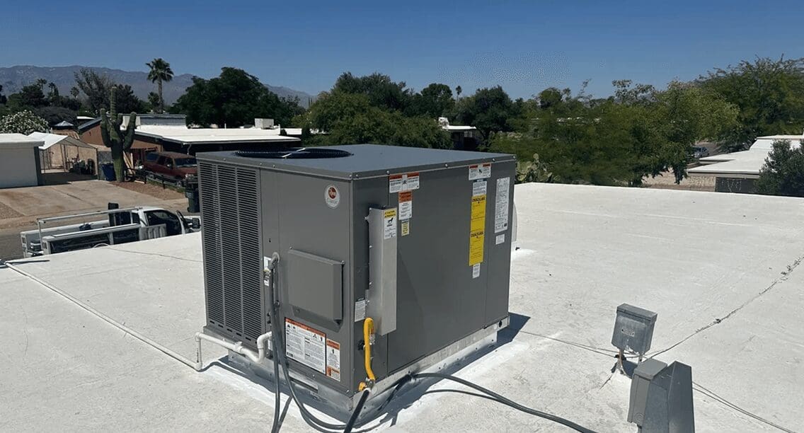 Rooftop air conditioning unit under clear sky.