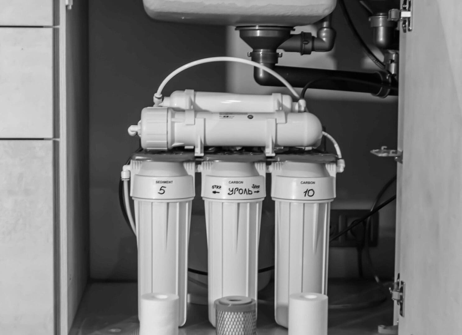 Under-sink water filtration system in cabinet.