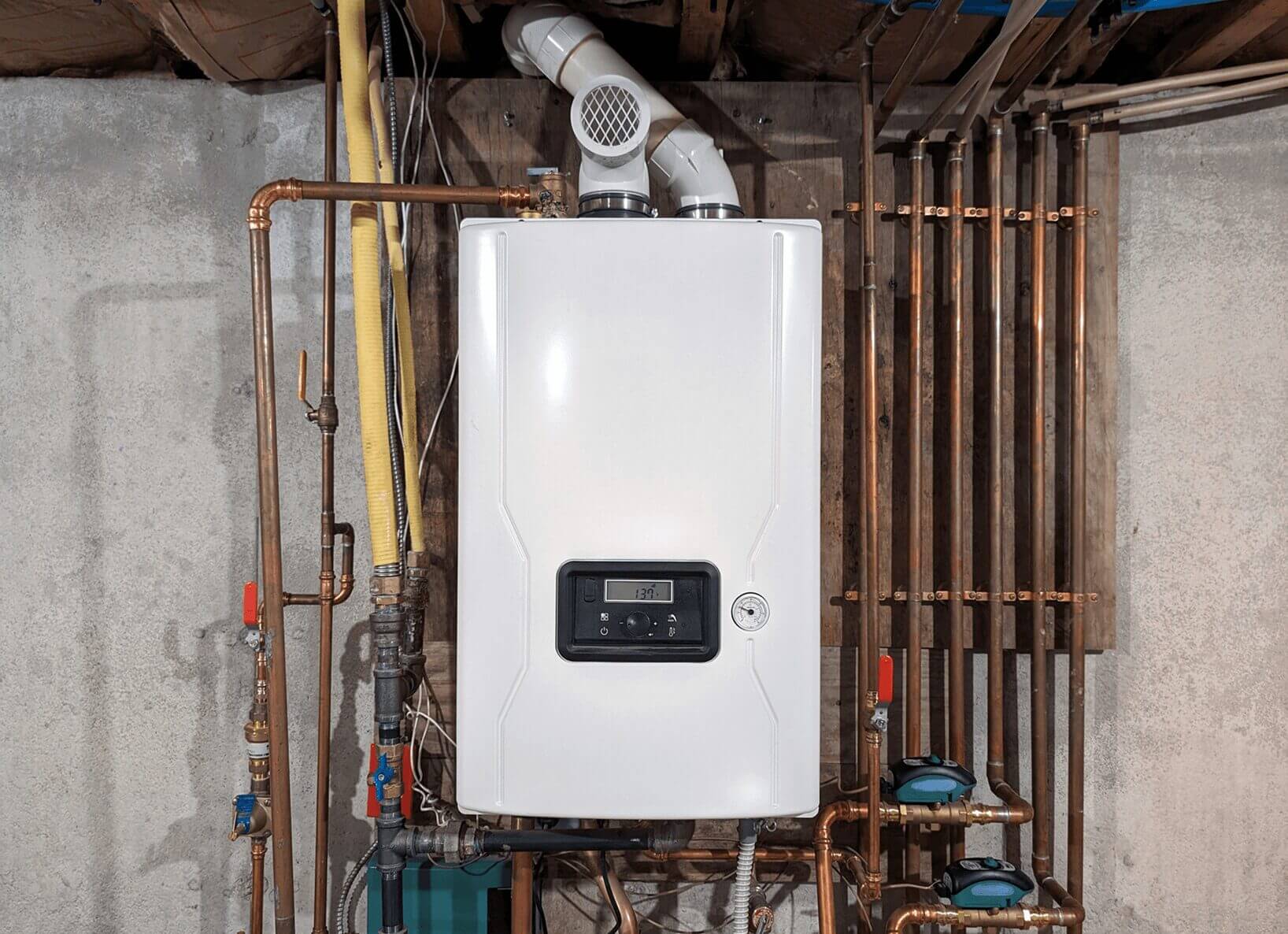 White boiler with pipes in a basement.