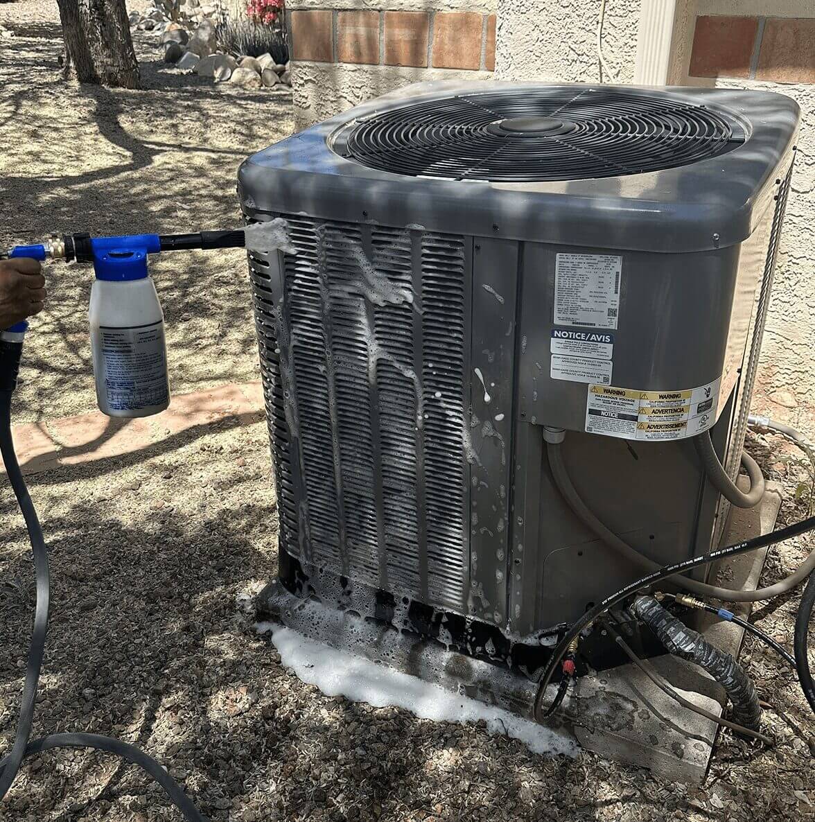 Cleaning an outdoor air conditioning unit.