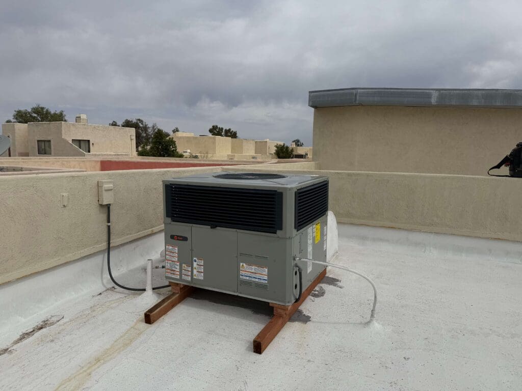 Rooftop air conditioning unit under cloudy sky.
