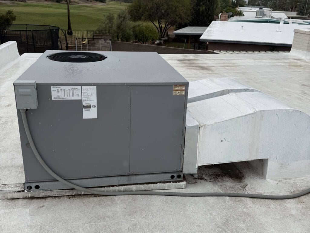 Rooftop air conditioning unit on flat surface.