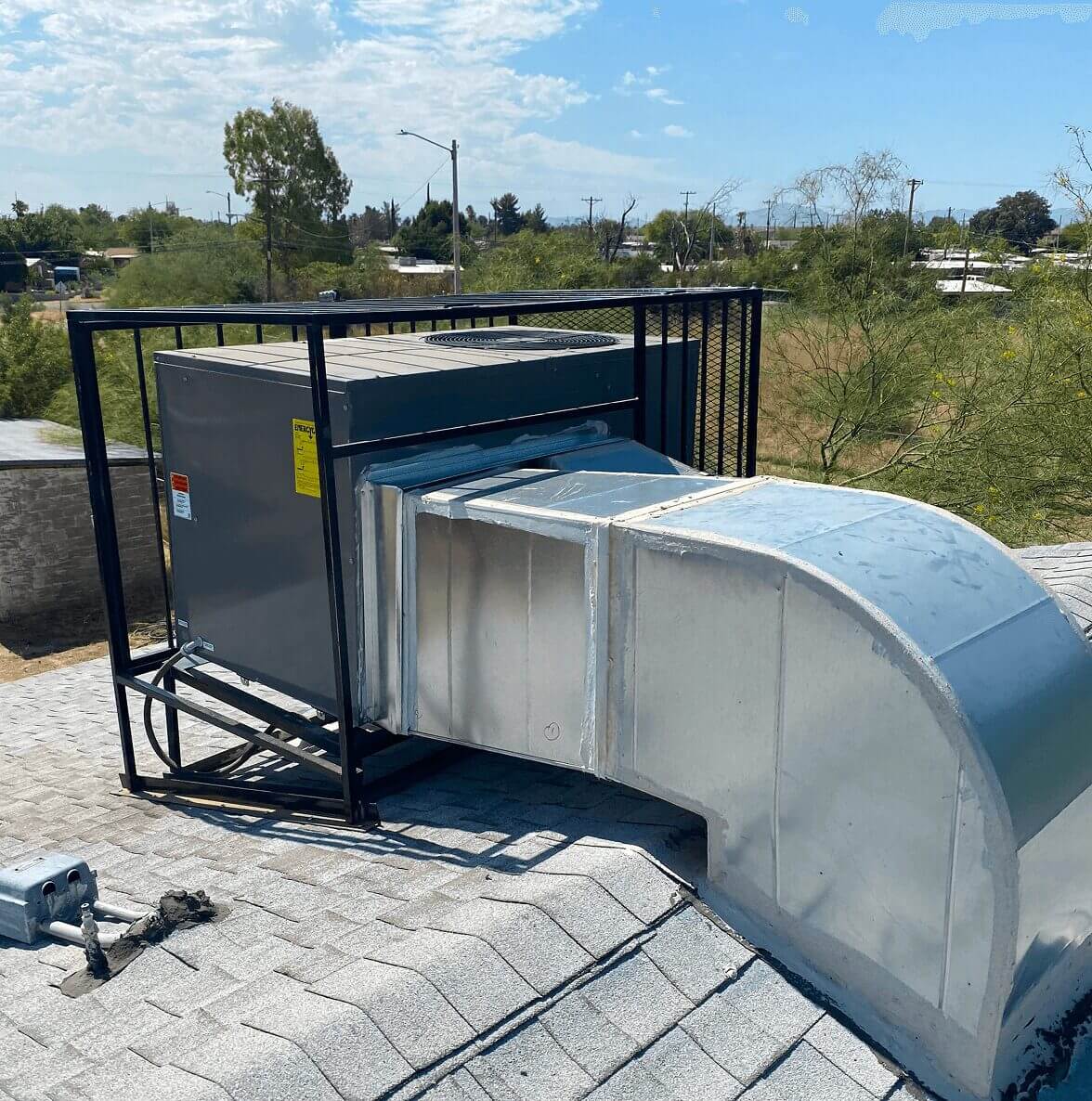 Rooftop HVAC unit under clear blue sky.
